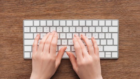 Partial-view-of-woman-typing-on-keyboard